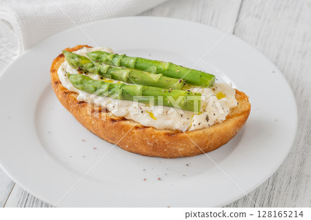 Grilled sandwich with white bread, stracciatella cheese, and green asparagus 128165214