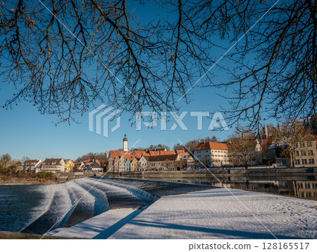 Historic Town Of Landsberg Am Lech In Bavaria: Winter Charm With A Frozen River And Colorful Houses Under A Clear Blue Sky Historic Town Of Landsberg Am Lech In Bavaria: Winter Charm With A Frozen River And Colorful Houses Under A Clear Blue Sky 128165517