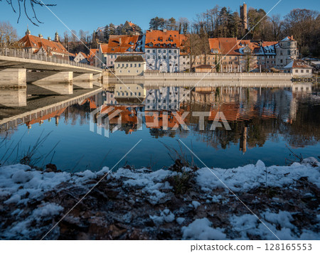 Historic Town Of Landsberg Am Lech In Bavaria: Winter Charm With A Frozen River And Colorful Houses Under A Clear Blue Sky 128165553