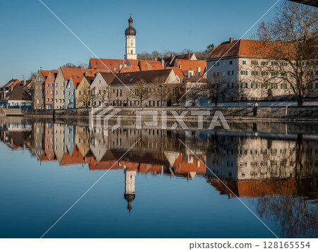 Historic Town Of Landsberg Am Lech In Bavaria: Winter Charm With A Frozen River And Colorful Houses Under A Clear Blue Sky Historic Town Of Landsberg Am Lech In Bavaria: Winter Charm With A Frozen River And Colorful Houses Under A Clear Blue Sky 128165554