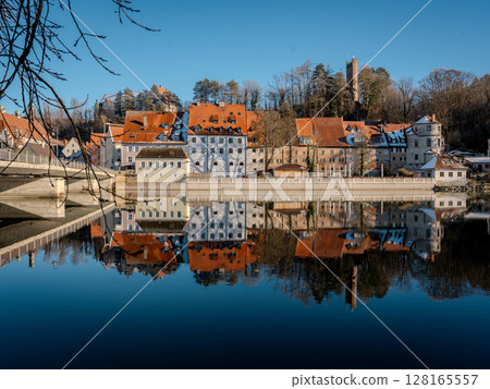 Historic Town Of Landsberg Am Lech In Bavaria: Winter Charm With A Frozen River And Colorful Houses Under A Clear Blue Sky 128165557