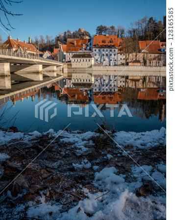 Historic Town Of Landsberg Am Lech In Bavaria: Winter Charm With A Frozen River And Colorful Houses Under A Clear Blue Sky Historic Town Of Landsberg Am Lech In Bavaria: Winter Charm With A Frozen River And Colorful Houses Under A Clear Blue Sky 128165585