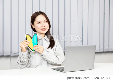 Woman in work clothes holding a beginner's mark 01 Woman in work clothes holding a beginner's mark 01 128165977