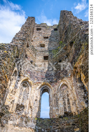 The aged walls and arched windows of Okor Castle stand tall against a bright blue sky, showcasing the architectural remnants near Prague. Czechia The aged walls and arched windows of Okor Castle stand tall against a bright blue sky, showcasing the architectural remnants near Prague. Czechia 128166314