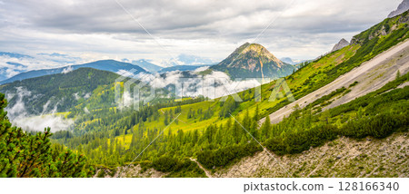 Clouds gently blanket the Low Tauern mountains in Austria, revealing lush green valleys and towering peaks. The tranquil atmosphere invites exploration and adventure in nature's beauty. Clouds gently blanket the Low Tauern mountains in Austria, revealing lush green valleys and towering peaks. The tranquil atmosphere invites exploration and adventure in nature's beauty. 128166340