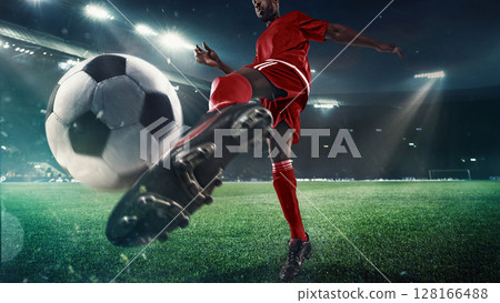 Soccer player strikes ball on 3D field under stadium lights in close-up action 128166488