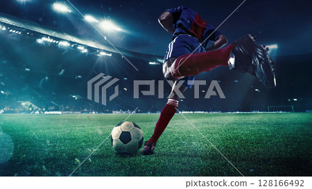 Football player preparing to shoot ball on 3D stadium field at night 128166492