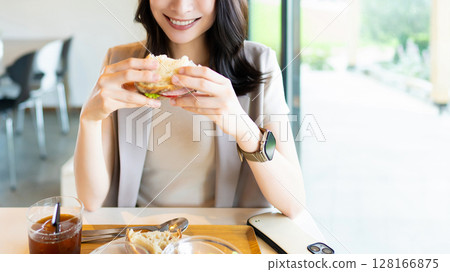微笑的女人在咖啡館吃午餐 微笑的女人在咖啡館吃午餐 128166875