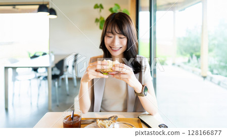 Smiling woman eating lunch at a cafe Smiling woman eating lunch at a cafe 128166877