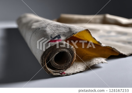 Old rolled paper revealing yellow inside, showcasing vintage texture and historical significance 128167233