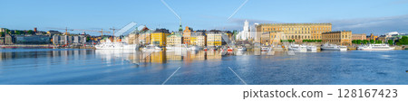 The Stockholm waterfront basks in the evening light, featuring the grandeur of the Royal Palace and the city reflection on the tranquil water. Stockholm, Sweden 128167423