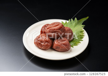 Pickled plums and shiso arranged on a black background Pickled plums and shiso arranged on a black background 128167523