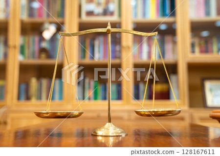 Close up to Golden vintage Scale Symbolic of Legal and Law section is standing on wood base in front of Library shelf. 128167611