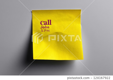 Reminder note on yellow sticky paper to call John at 5 PM in an office setting 128167922