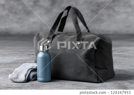 Stylish gym bag with water bottle and towel on gray background showcasing fitness essentials 128167953