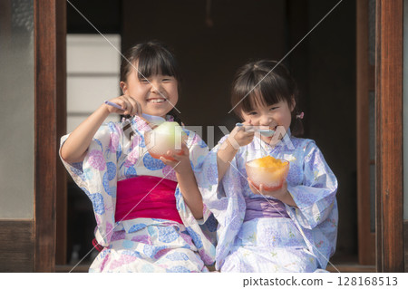 穿著浴衣的姊妹在陽台上吃刨冰 穿著浴衣的姊妹在陽台上吃刨冰 128168513