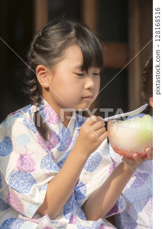 Sisters in yukata eating shaved ice on the veranda 128168516