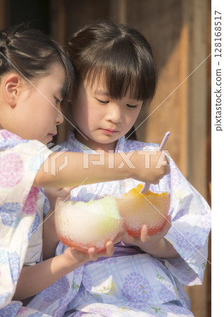 Sisters in yukata eating shaved ice on the veranda Sisters in yukata eating shaved ice on the veranda 128168517