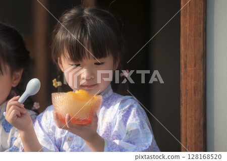 Sisters in yukata eating shaved ice on the veranda Sisters in yukata eating shaved ice on the veranda 128168520