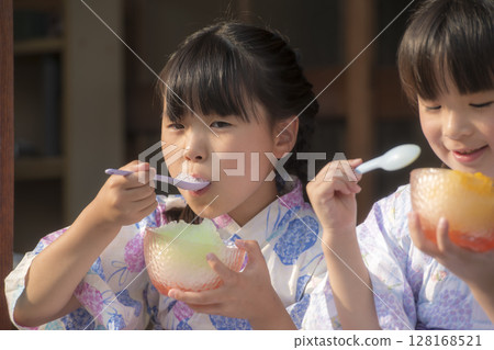 Sisters in yukata eating shaved ice on the veranda Sisters in yukata eating shaved ice on the veranda 128168521