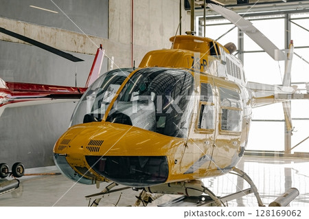 Yellow tourist helicopter in hangar Yellow tourist helicopter in hangar 128169062