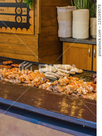 Street food stall with grilled sausages and skewered meat outdoor food market. High quality photo Street food stall with grilled sausages and skewered meat outdoor food market. High quality photo 128169578