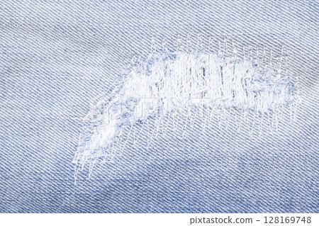 Closeup detail of torn on blue jeans. Denim jeans texture. Closeup detail of torn on blue jeans. Denim jeans texture. 128169748