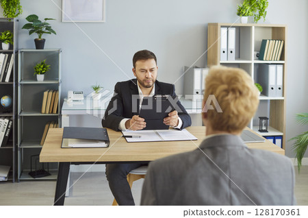 Business recruitment manager meeting with candidate and conducting job interview 128170361