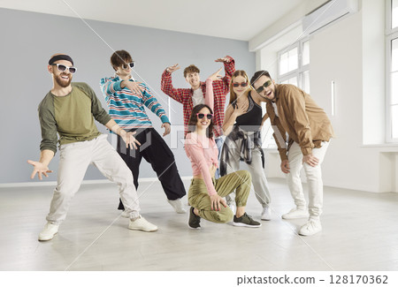 Team of talented young people posing in dance studio, wearing casual clothing and trendy sunglasses 128170362