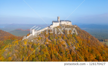 The stunning aerial view showcases Bezdez medieval castle surrounded by vibrant autumn foliage, highlighting the beauty of the landscape and historical architecture in the season. 128170427