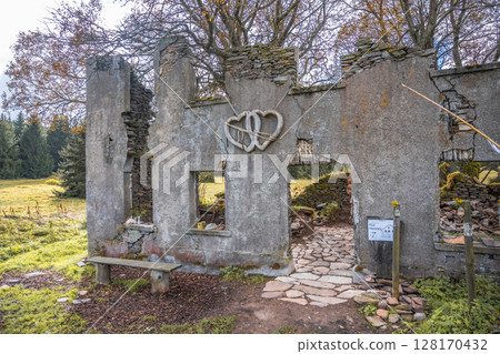The remnants of the historic Konigsmuhle settlement showcase crumbling walls and a heart decoration. Nestled in the Ore Mountains of Czechia, nature slowly reclaims this once vibrant area. 128170432