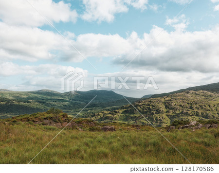Majestic mountains dominate the horizon, their slopes covered in vibrant green vegetation. A stunning panorama. Majestic mountains dominate the horizon, their slopes covered in vibrant green vegetation. A stunning panorama. 128170586
