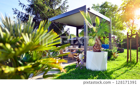 Modern aluminum pergola with stylish garden furniture in a beautiful garden. Modern aluminum pergola with stylish garden furniture in a beautiful garden. 128171391