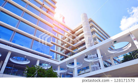 Downtown corporate business district architecture. Glass reflective office buildings against blue sky and sun light. Economy, finances, business activity concept. Abstract modern architecture fragment Downtown corporate business district architecture. Glass reflective office buildings against blue sky and sun light. Economy, finances, business activity concept. Abstract modern architecture fragment 128171570