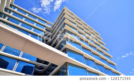 Downtown corporate business district architecture. Glass reflective office buildings against blue sky and sun light. Economy, finances, business activity concept. Abstract modern architecture fragment Downtown corporate business district architecture. Glass reflective office buildings against blue sky and sun light. Economy, finances, business activity concept. Abstract modern architecture fragment 128171591