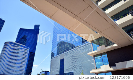 Downtown corporate business district architecture. Glass reflective office buildings against blue sky and sun light. Economy, finances, business activity concept. Abstract modern architecture fragment 128171606