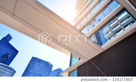Downtown corporate business district architecture. Glass reflective office buildings against blue sky and sun light. Economy, finances, business activity concept. Abstract modern architecture fragment Downtown corporate business district architecture. Glass reflective office buildings against blue sky and sun light. Economy, finances, business activity concept. Abstract modern architecture fragment 128171607