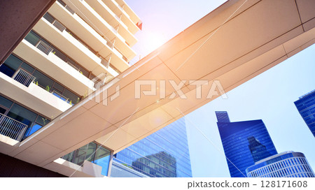Downtown corporate business district architecture. Glass reflective office buildings against blue sky and sun light. Economy, finances, business activity concept. Abstract modern architecture fragment Downtown corporate business district architecture. Glass reflective office buildings against blue sky and sun light. Economy, finances, business activity concept. Abstract modern architecture fragment 128171608