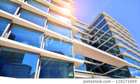 Downtown corporate business district architecture. Glass reflective office buildings against blue sky and sun light. Economy, finances, business activity concept. Abstract modern architecture fragment Downtown corporate business district architecture. Glass reflective office buildings against blue sky and sun light. Economy, finances, business activity concept. Abstract modern architecture fragment 128171609