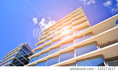 Downtown corporate business district architecture. Glass reflective office buildings against blue sky and sun light. Economy, finances, business activity concept. Abstract modern architecture fragment Downtown corporate business district architecture. Glass reflective office buildings against blue sky and sun light. Economy, finances, business activity concept. Abstract modern architecture fragment 128171617