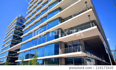 Downtown corporate business district architecture. Glass reflective office buildings against blue sky and sun light. Economy, finances, business activity concept. Abstract modern architecture fragment 128171620