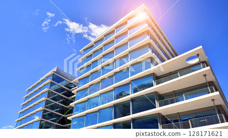 Downtown corporate business district architecture. Glass reflective office buildings against blue sky and sun light. Economy, finances, business activity concept. Abstract modern architecture fragment Downtown corporate business district architecture. Glass reflective office buildings against blue sky and sun light. Economy, finances, business activity concept. Abstract modern architecture fragment 128171621