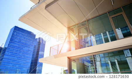Downtown corporate business district architecture. Glass reflective office buildings against blue sky and sun light. Economy, finances, business activity concept. Abstract modern architecture fragment 128171630