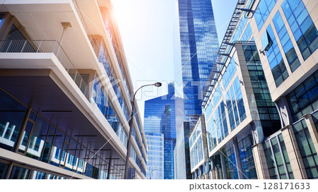 Downtown corporate business district architecture. Glass reflective office buildings against blue sky and sun light. Economy, finances, business activity concept. Abstract modern architecture fragment Downtown corporate business district architecture. Glass reflective office buildings against blue sky and sun light. Economy, finances, business activity concept. Abstract modern architecture fragment 128171633