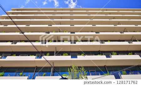 City life, urban landscape and ecology. Modern office complex with glass facades and smooth lines against backdrop of green trees, concept of modern architecture. Organically building into nature. City life, urban landscape and ecology. Modern office complex with glass facades and smooth lines against backdrop of green trees, concept of modern architecture. Organically building into nature. 128171762