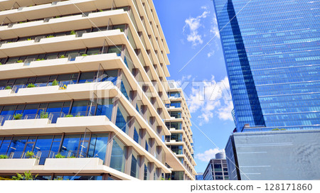 Downtown corporate business district architecture. Glass reflective office buildings against blue sky and sun light. Economy, finances, business activity concept. Abstract modern architecture fragment Downtown corporate business district architecture. Glass reflective office buildings against blue sky and sun light. Economy, finances, business activity concept. Abstract modern architecture fragment 128171860