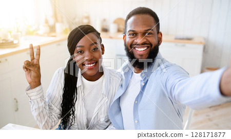 Cheerful Black Spouses Taking Selfie While Drinking Morning Coffee Together, Happy African American Couple Posing For Photo, Sitting At Table In Kitchen And Smiling At Camera, Closeup Shot Cheerful Black Spouses Taking Selfie While Drinking Morning Coffee Together, Happy African American Couple Posing For Photo, Sitting At Table In Kitchen And Smiling At Camera, Closeup Shot 128171877