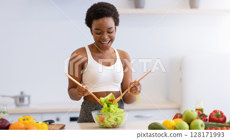 Happy Fit African Lady Cooking Fresh Vegetable Salad For Healthy Dinner Slimming Standing In Modern Kitchen At Home. Weight Loss Food, Dieting Recipes And Nutrition Concept Happy Fit African Lady Cooking Fresh Vegetable Salad For Healthy Dinner Slimming Standing In Modern Kitchen At Home. Weight Loss Food, Dieting Recipes And Nutrition Concept 128171993