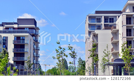 European residential architecture harmonizing with nature. Eco-friendly living in city with greens. Eco apartment building saving energy and fresh air concept.  128172166