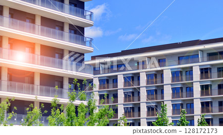 European residential architecture harmonizing with nature. Eco-friendly living in city with greens. Eco apartment building saving energy and fresh air concept. European residential architecture harmonizing with nature. Eco-friendly living in city with greens. Eco apartment building saving energy and fresh air concept. 128172173